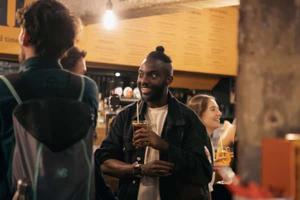 man laughing holding drink