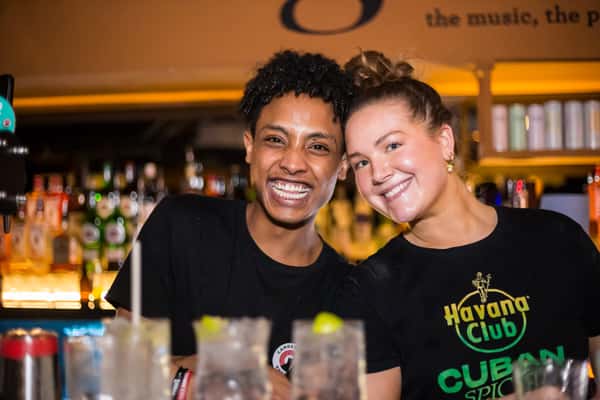 a boy and a girl smiling behind the bar 