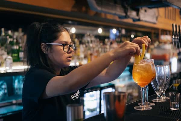 bartender placing garnish in cocktail