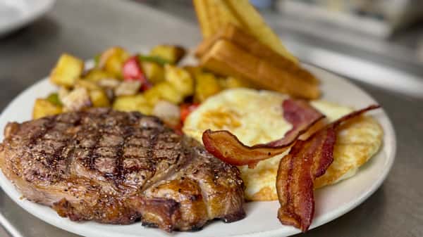 Grilled steak and eggs breakfast with bacon, toast, and seasoned potatoes