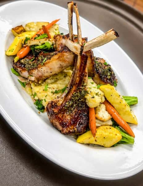 Grilled pork chops served with roasted vegetables and creamy potato gratin