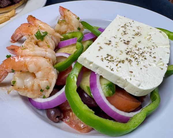Fresh Greek salad with shrimp, feta cheese, tomatoes, red onions, and cucumbers