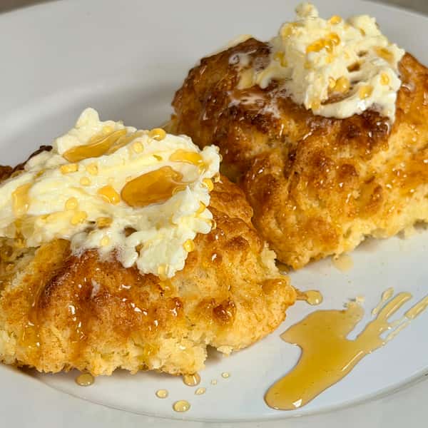 Fried chicken and waffles topped with whipped butter, syrup, and powdered sugar