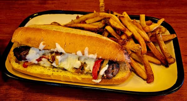Grilled sausage hoagie with melted cheese, sautéed peppers and onions, served with a side of crispy French fries.