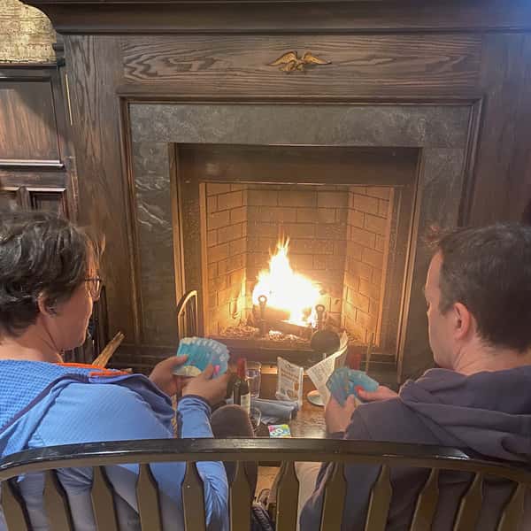 couple in front of fireplace playing cards
