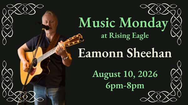 Eamonn Sheehan with guitar, singing at the mic