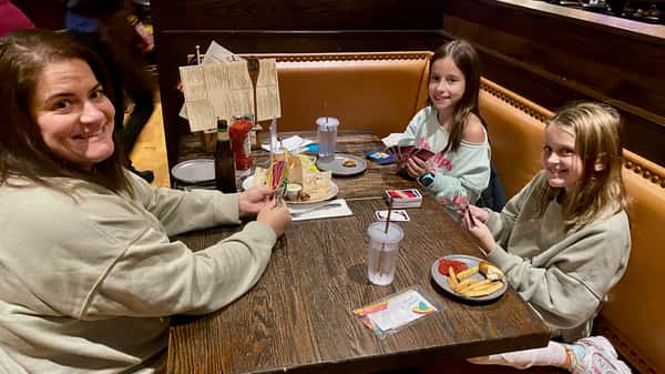 mom and 2 little daughters playing cards