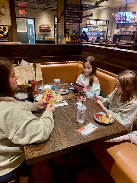 mom and 2 little daughters playing cards