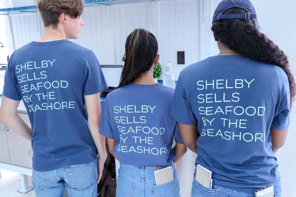 staff members wearing shirts that read "Shelby sells seafood by the seashore"