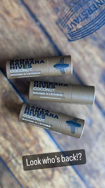 Three coconut lip balms from Santa Barbara Hives on a wooden table