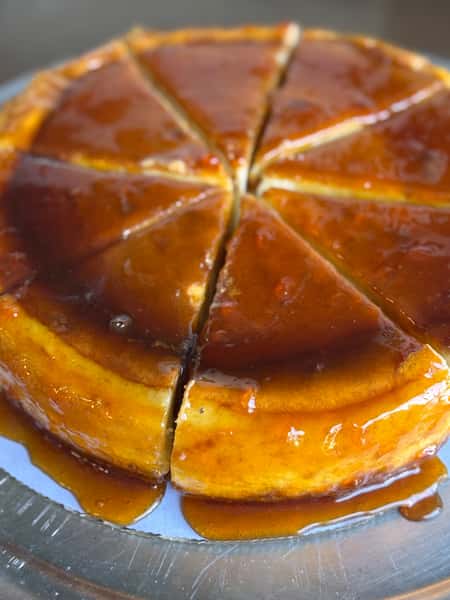 Sliced flan cake covered in caramel syrup