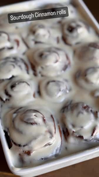 Tray of sourdough cinnamon rolls covered in white icing