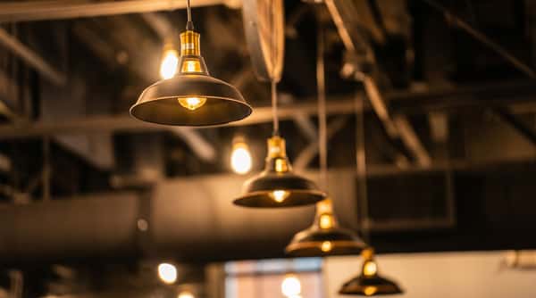 Industrial-style pendant lights illuminating the Alidade Brewing taproom, creating a warm and inviting atmosphere for craft beer guests.