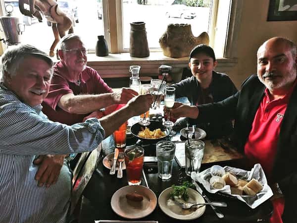 table of four enjoying a meal and toasting.