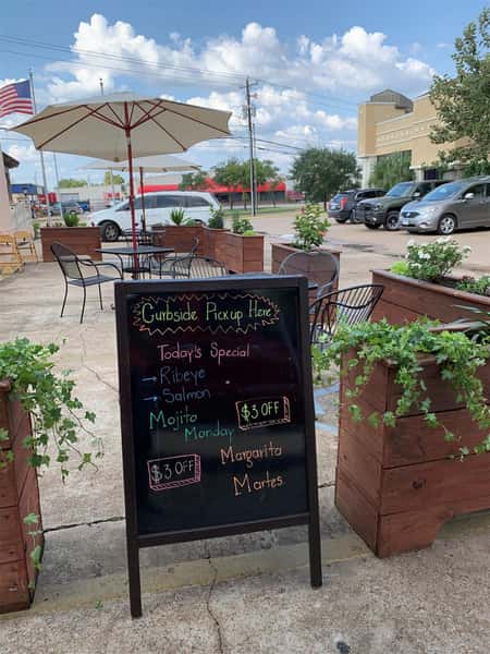 outside dining area with specials on a chalkboard outside
