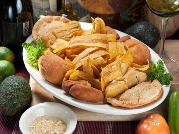Sampler plate with 4 Croquetas, 2 Tamales, 2 Empanadas, 2 Papas Rellenas, and Mariquitas