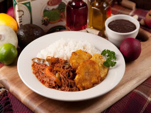 Ropa Vieja. Shredded beef slow-cooked in tomato and wine sauce. White rice and tostones on the side.