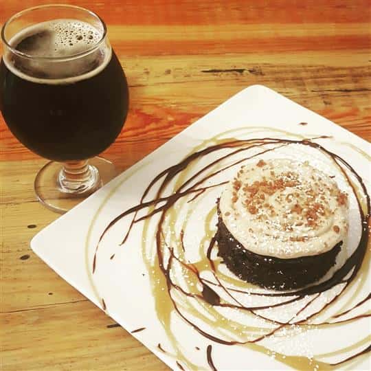 decorated dessert with syrup with a glass of craft beer
