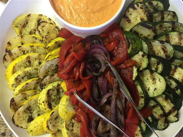 roasted vegetables on a platter with dipping sauce