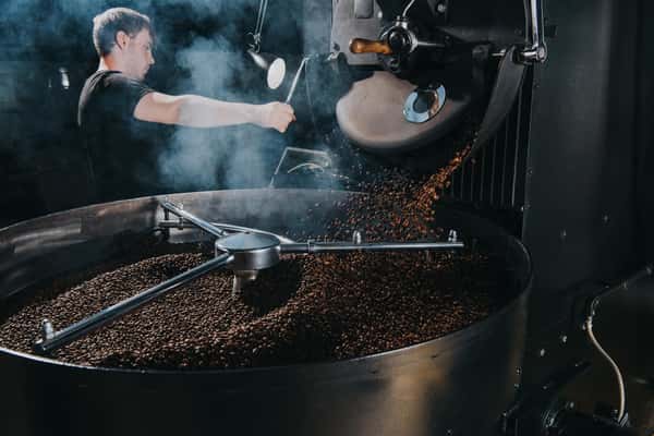 employee mixing ingredients in large container