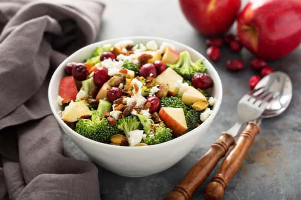 salad topped with broccoli, grapes and apples