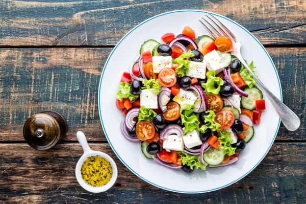 salad with tomatoes, onions, olives and croutons in a bowl