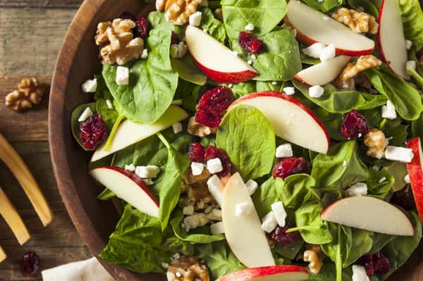 salad topped with feta cheese, cranberries and apples