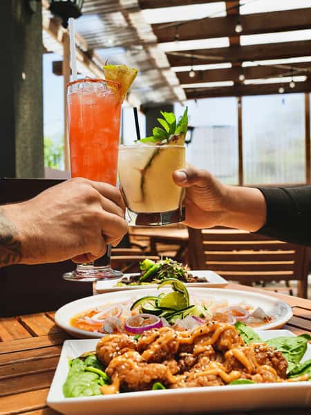 Refreshing tropical cocktails served with Mexican seafood appetizers and ceviche on a sunny outdoor patio