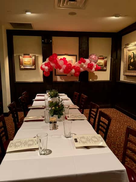 Private dining room decorated with red and white balloons for a special event.