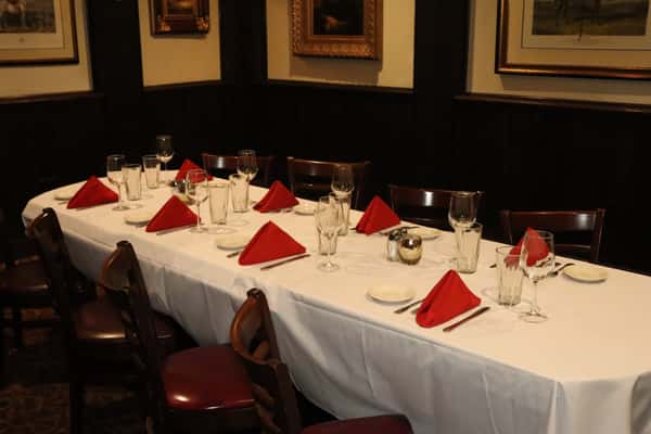 Banquet-style dining room prepared for a private event with elegant table settings.