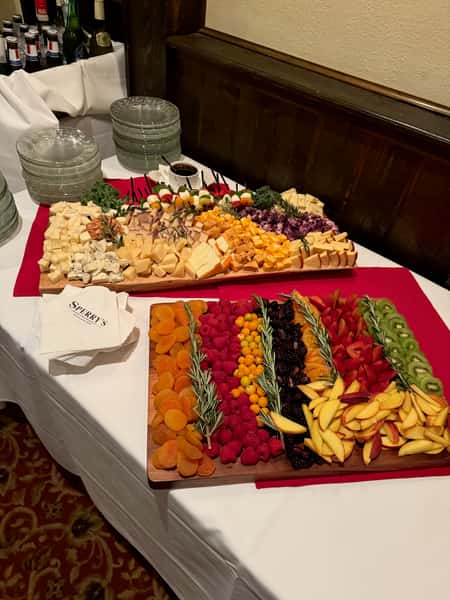 Elegant charcuterie board with cheeses, fresh fruit, and assorted appetizers.