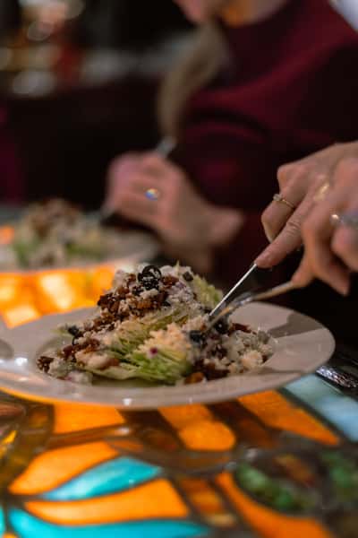 Close-up of a fresh salad being served at the table.