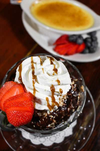 Hot fudge sundae topped with whipped cream and caramel drizzle.