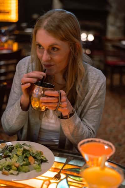 Guest holding a handcrafted cocktail while dining.