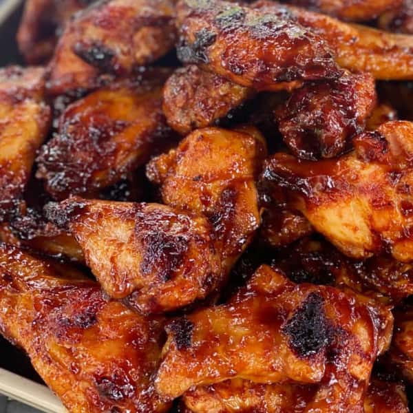 Smoky barbecue chicken wings glazed with a sticky, charred BBQ sauce, perfect for a Southern-style comfort food meal.