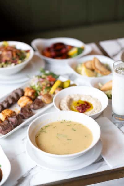 Creamy lentil soup served with grilled kebabs, hummus, and traditional Mediterranean sides