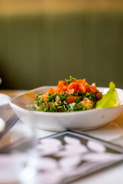Fresh tabbouleh salad with parsley, tomatoes, and lemon served at a Mediterranean restaurant