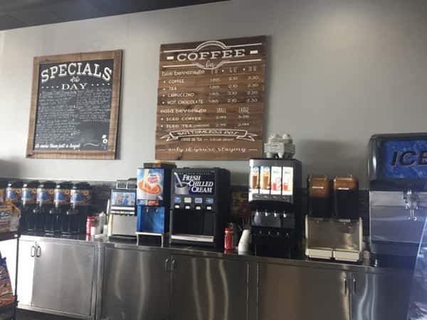 Back of the counter with two signs, one sign that says specials and other that has the coffee menu