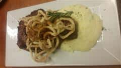 Meat topped over mashed potatoes