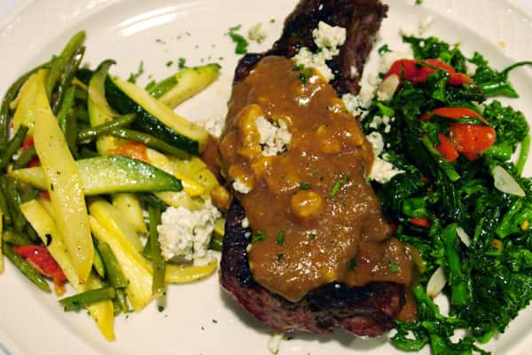 Ribs topped with gravy with a side of vegetables