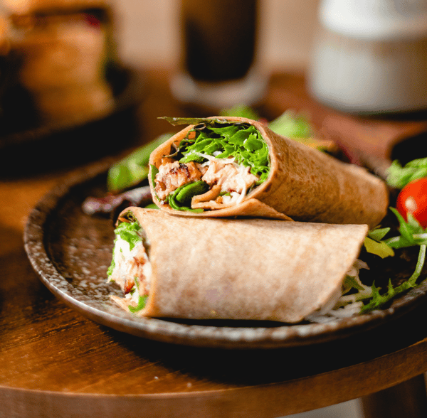 Two halves of a sandwich wrap on a plate