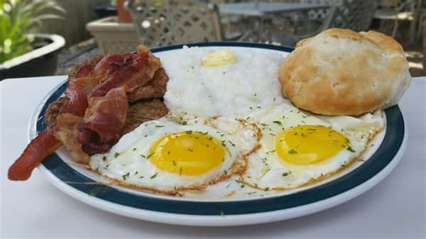 Eggs, Bacon, grits, and sausage with a biscuit