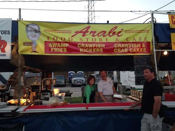 Chefs cooking outside with sign