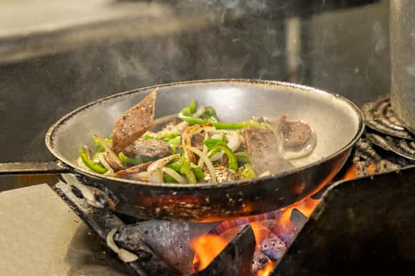 sausage and peppers cooking in pan