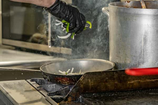 Chef cooking with sizzling pan