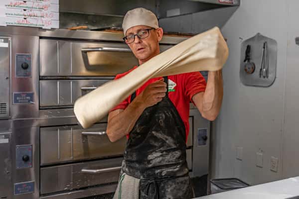 Pizza chef pulling pizza dough