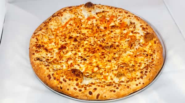 Buffalo chicken pizza on a metal tray, topped with melted mozzarella and bright orange hot sauce swirls.