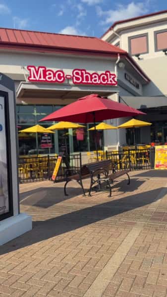 Exterior of Mac-Shack restaurant with red umbrellas and outdoor seating