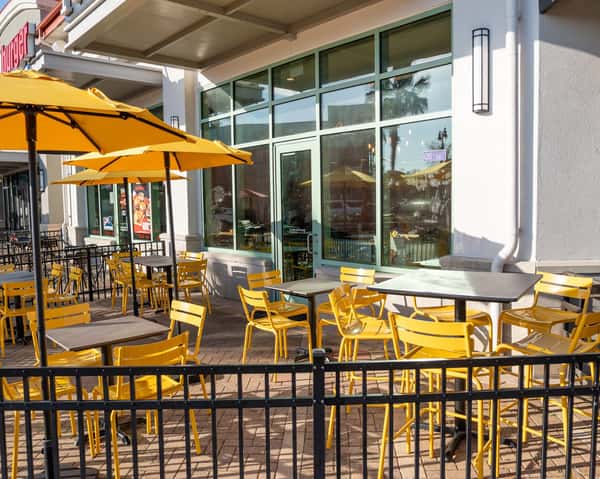 Outdoor patio seating area with yellow umbrellas and tables
