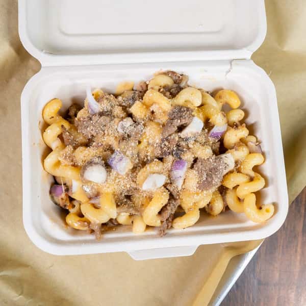 Mac and cheese with steak bites in a takeout container